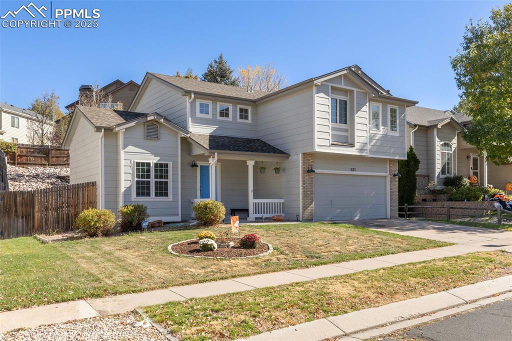 Image 2 of 36: Traditional home featuring brick siding, an attached garage, driveway, cove