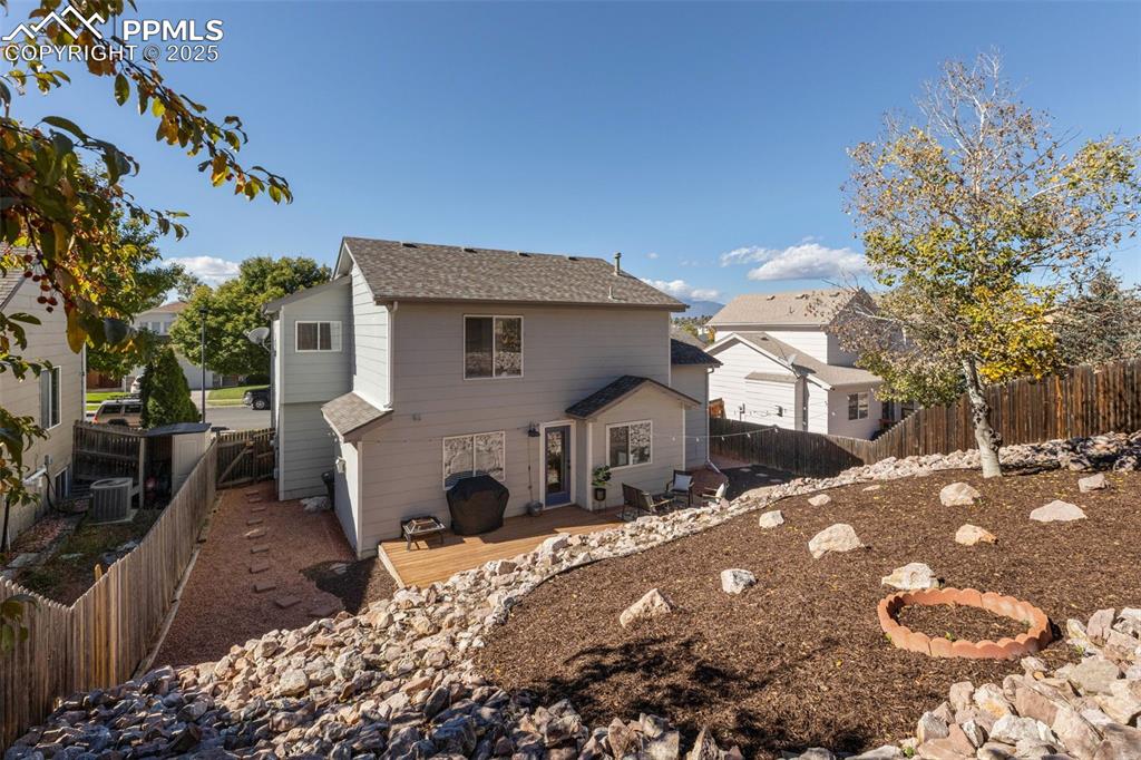 Image 30 of 36: Rear view of house with a fenced backyard, a deck, and a shingled roof