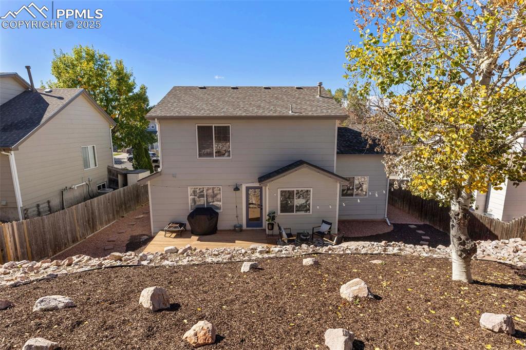Image 31 of 36: Rear view of house with roof with shingles, a fenced backyard, and a patio