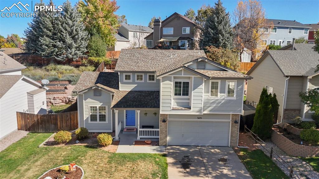 Image 32 of 36: Traditional home with covered porch, brick siding, a shingled roof, and dri