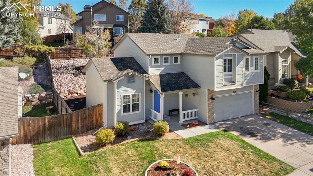 Image 4 of 36: Traditional home with covered porch, a shingled roof, driveway, an attached