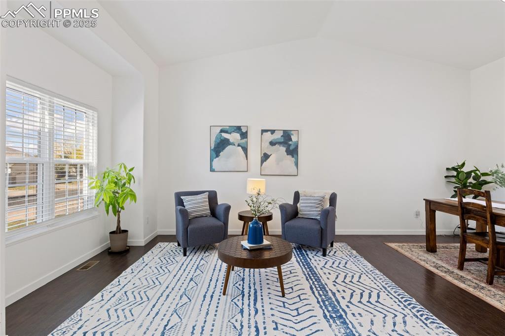 Image 9 of 36: Sitting room with dark wood-style floors and lofted ceiling