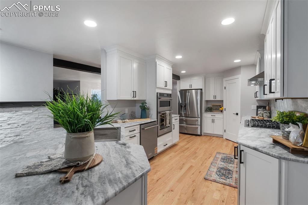 Image 12 of 48: Kitchen featuring tasteful backsplash, appliances with stainless steel fini