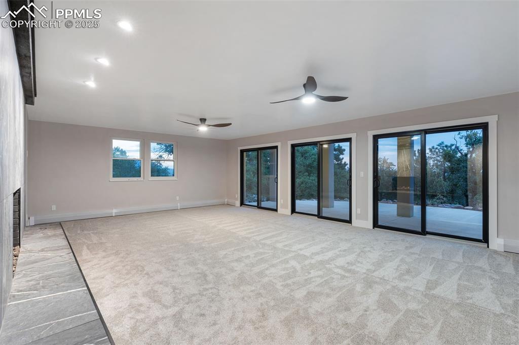 Image 24 of 48: Unfurnished living room featuring carpet flooring, a fireplace, and a ceili