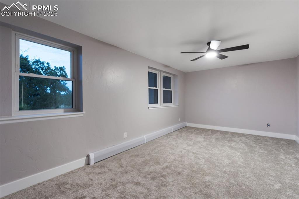Image 30 of 48: Empty room with carpet and a ceiling fan