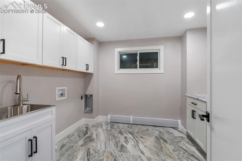 Image 33 of 48: Laundry area with cabinet space, washer hookup, recessed lighting, hookup f