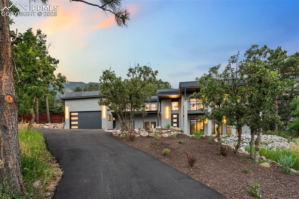 Image 38 of 48: Modern home featuring an attached garage, driveway, and stucco siding