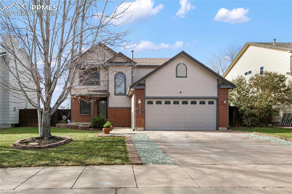 Caption: Traditional-style house featuring brick siding and driveway