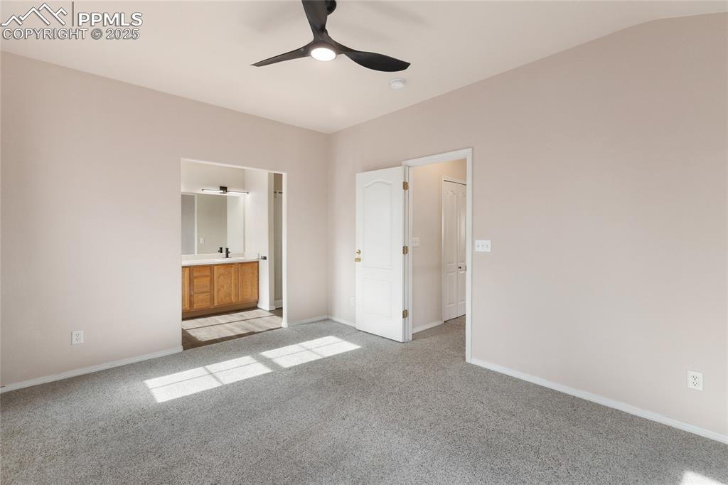 Image 16 of 37: Unfurnished bedroom with light colored carpet, connected bathroom, and ceil