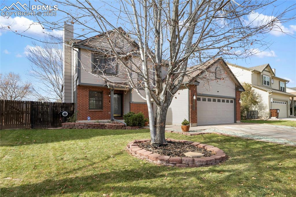 Image 2 of 37: Traditional home with brick siding, concrete driveway, and a chimney