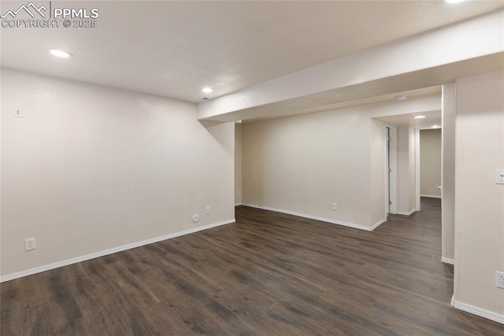 Image 27 of 37: Finished below grade area with recessed lighting and dark wood-type floorin