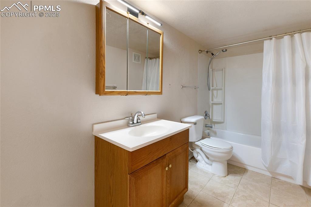Image 29 of 37: Full bath featuring vanity, shower / bath combo, and light tile patterned f