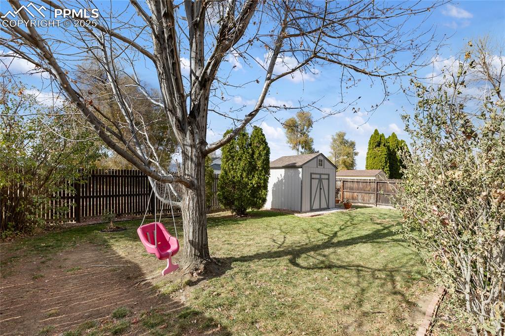 Image 35 of 37: Fenced backyard featuring a storage shed