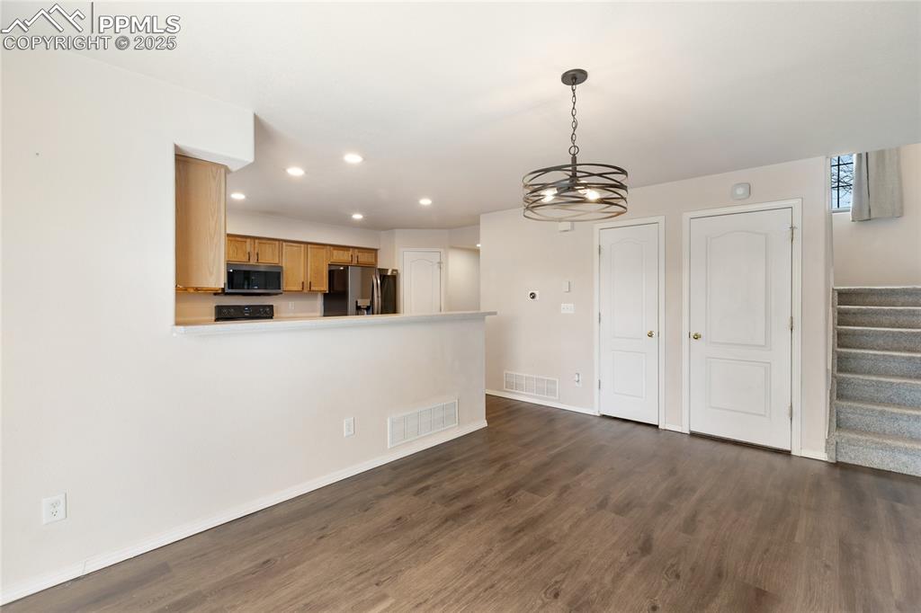 Image 9 of 37: Kitchen with dark wood-style flooring, stainless steel appliances, recessed