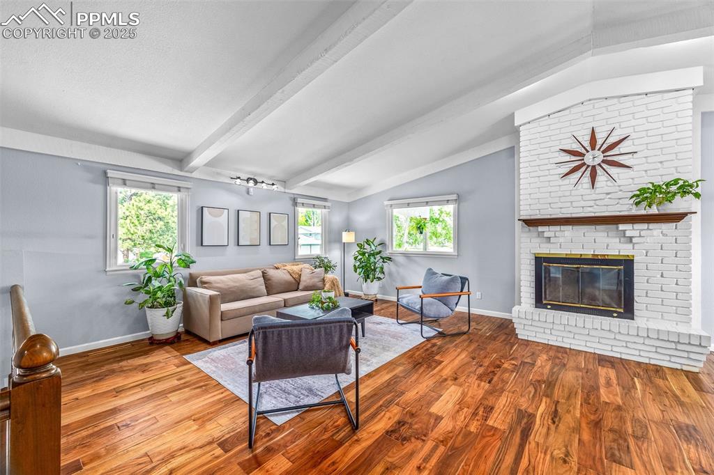 Image 10 of 47: Living room featuring wood finished floors and a fireplace