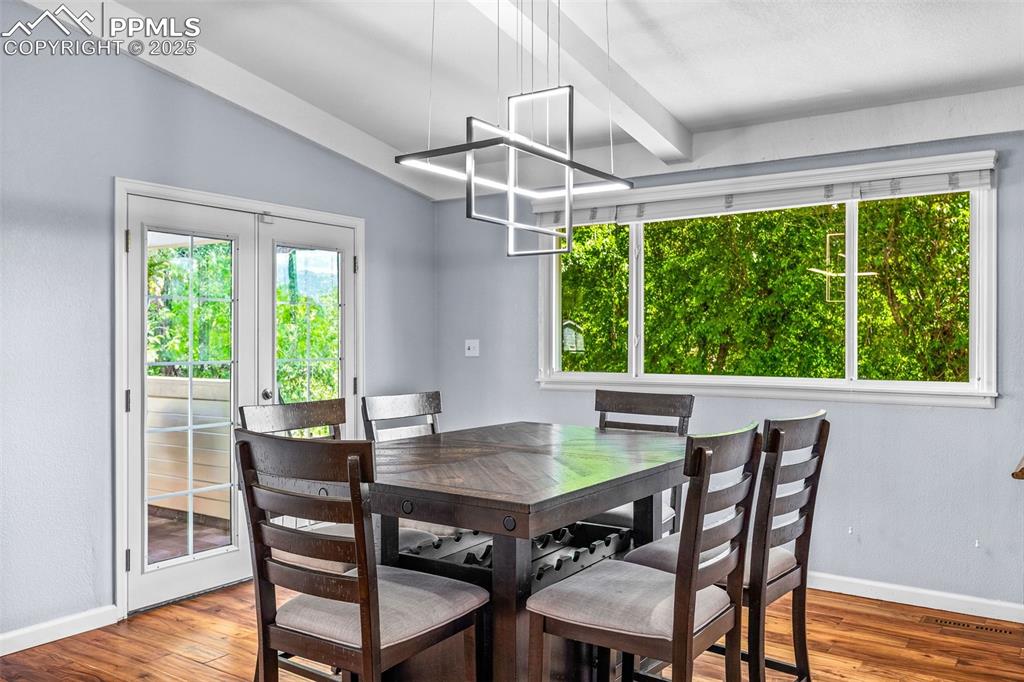 Image 14 of 47: Dining space featuring wood finished floors and beam ceiling