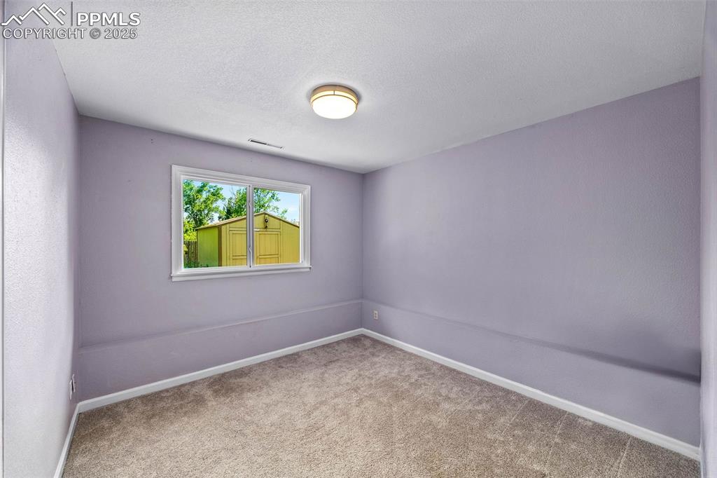 Image 20 of 47: Empty room with carpet flooring and a textured ceiling