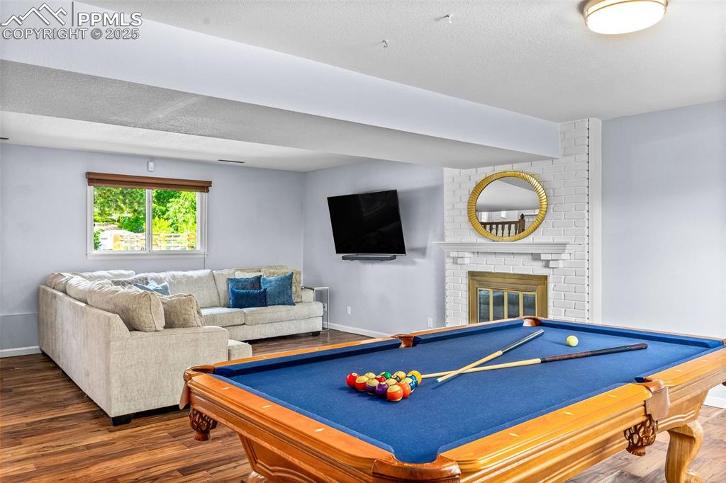 Image 26 of 47: Game room featuring wood finished floors, billiards, a textured ceiling, an