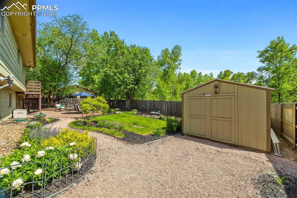 Image 34 of 47: Fenced backyard with a patio and a shed
