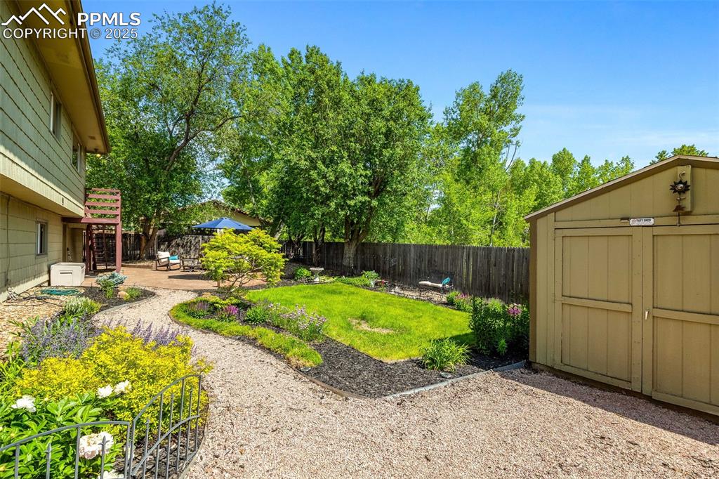 Image 37 of 47: Fenced backyard featuring a patio area and a storage shed