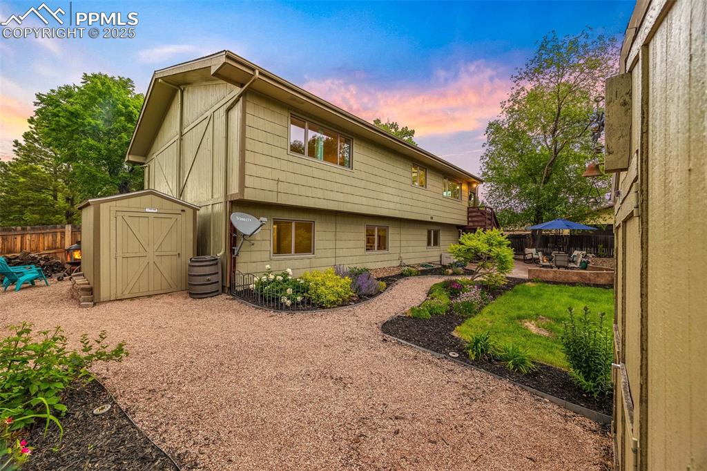 Image 43 of 47: Back of property featuring a storage unit, a fenced backyard, and a patio a