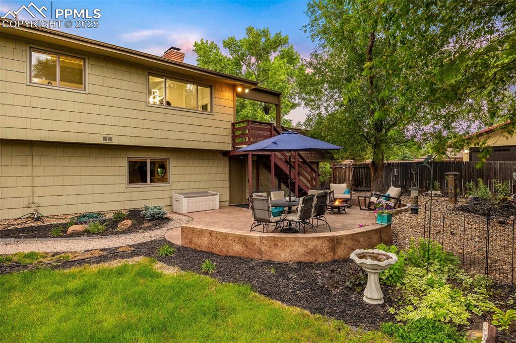 Image 45 of 47: Back of house featuring a chimney, a patio, stairs, a deck, and an outdoor 