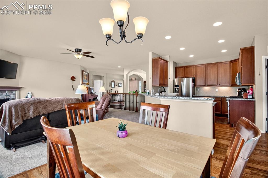 Image 12 of 48: Dining area with arched walkways, recessed lighting, dark wood-style floori