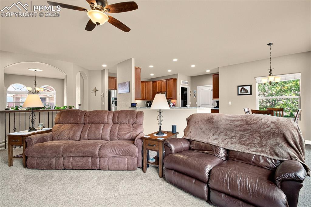 Image 17 of 48: Living room with a chandelier, carpet, ceiling fan, and recessed lighting