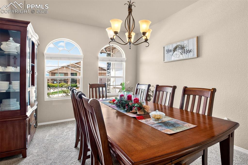 Image 6 of 48: Dining area featuring healthy amount of natural light, light carpet, a chan