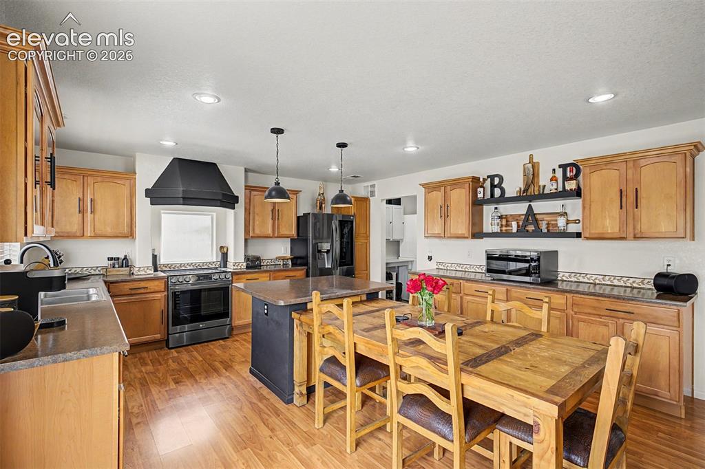 Image 12 of 43: A sleek center island with dual pendant lighting sits at the center of this