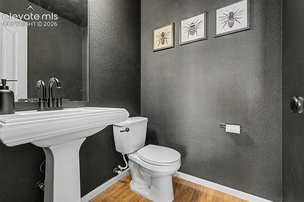 Image 16 of 43: A bold charcoal accent wall, sleek white pedestal sink, and matte-black fix