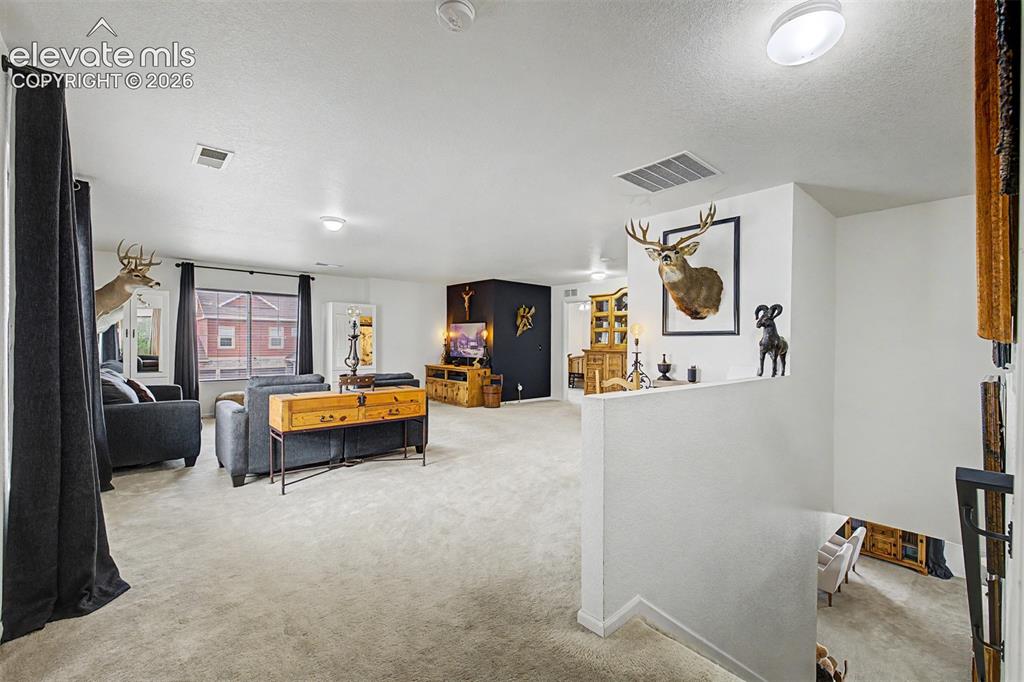 Image 17 of 43: At the top of the stairs, a generous loft space opens up with room to roam,