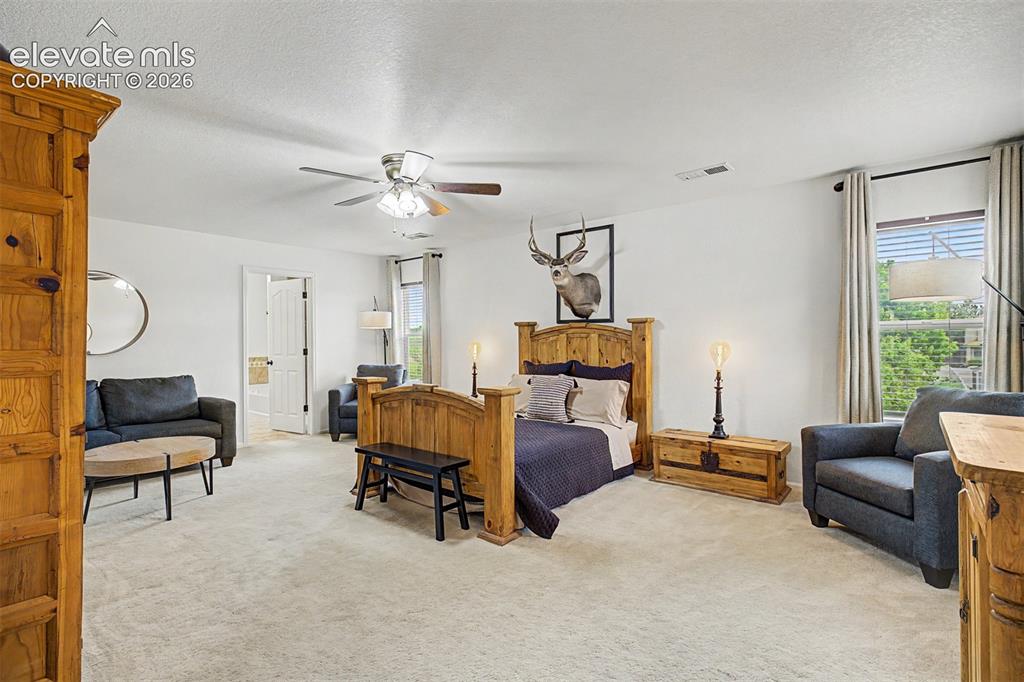 Image 20 of 43: The primary suite offers an impressive footprint with space for a full sitt