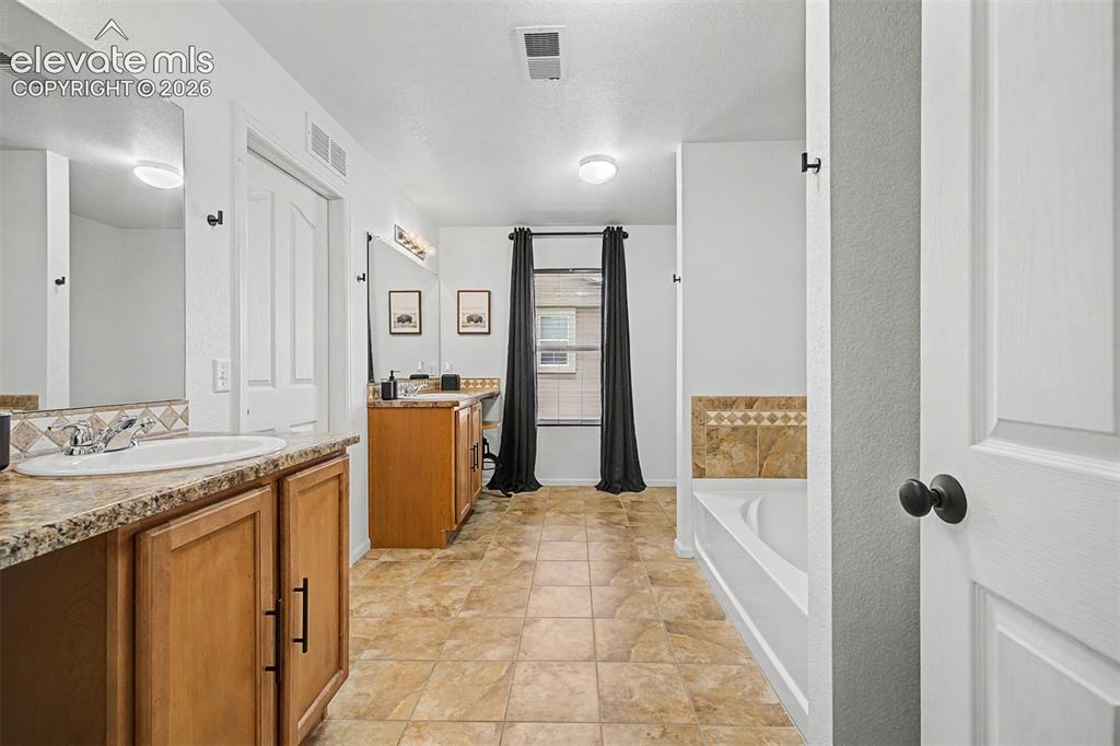 Image 25 of 43: The depth of this primary bathroom is remarkable — with separate vanity zon