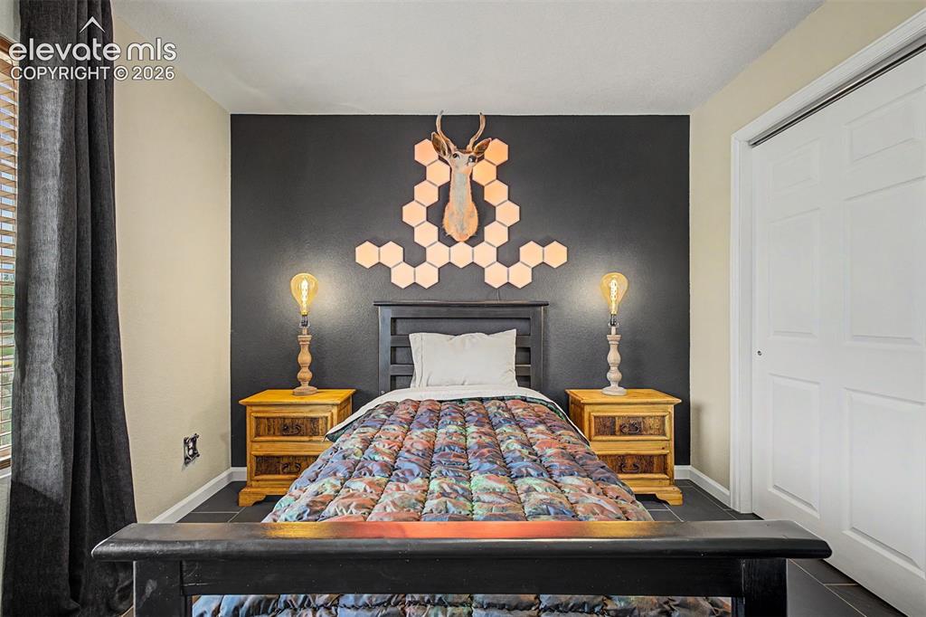 Image 27 of 43: This main level secondary bedroom makes a bold design statement with a dram