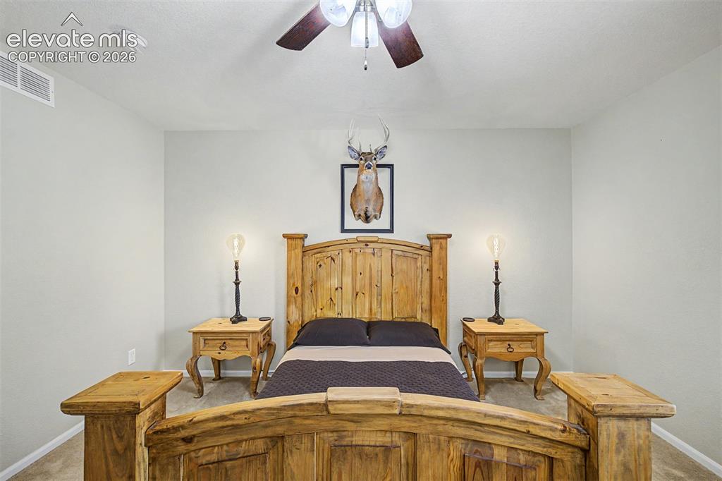 Image 31 of 43: The intimate scale and warm tones of this bedroom create a restful environm