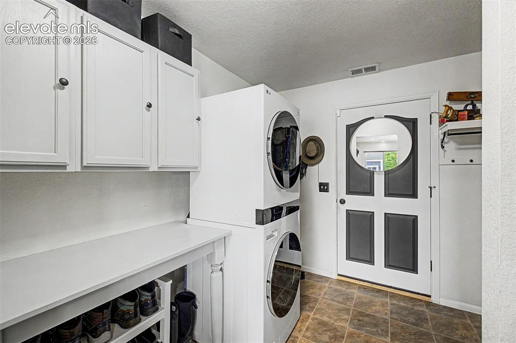 Image 35 of 43: The dedicated laundry and mudroom is thoughtfully laid out with cabinetry,