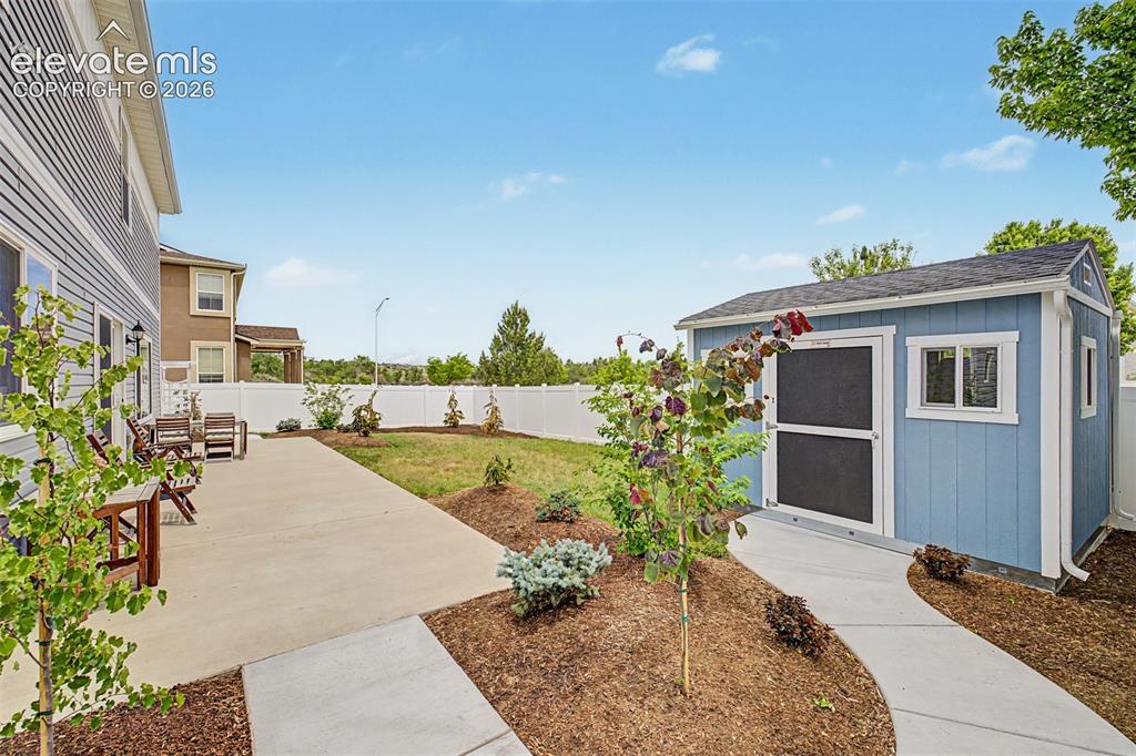 Image 38 of 43: The fully fenced backyard is a true blank canvas, with a concrete patio, fr