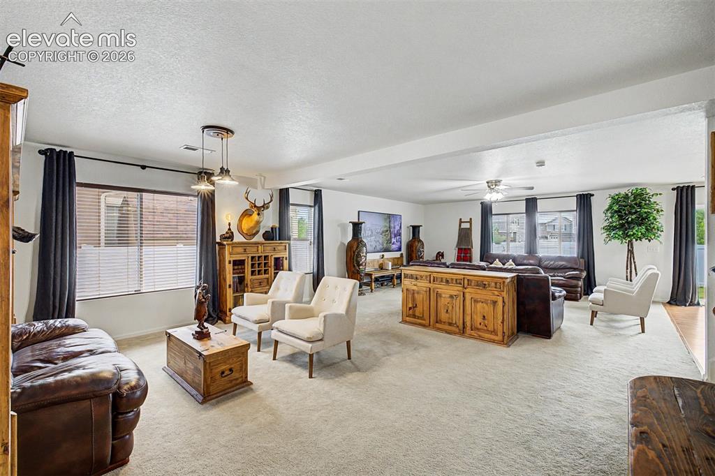 Image 6 of 43: Modern pendant lighting, a carved mirror, and statement furnishings fill th