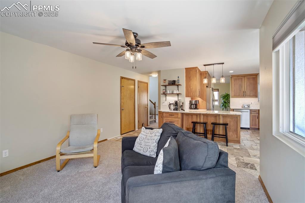 Image 13 of 50: Living area with ceiling fan and light colored carpet