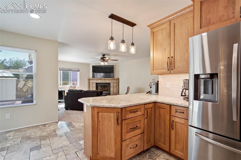 Image 17 of 50: Kitchen with stainless steel refrigerator with ice dispenser, a peninsula,