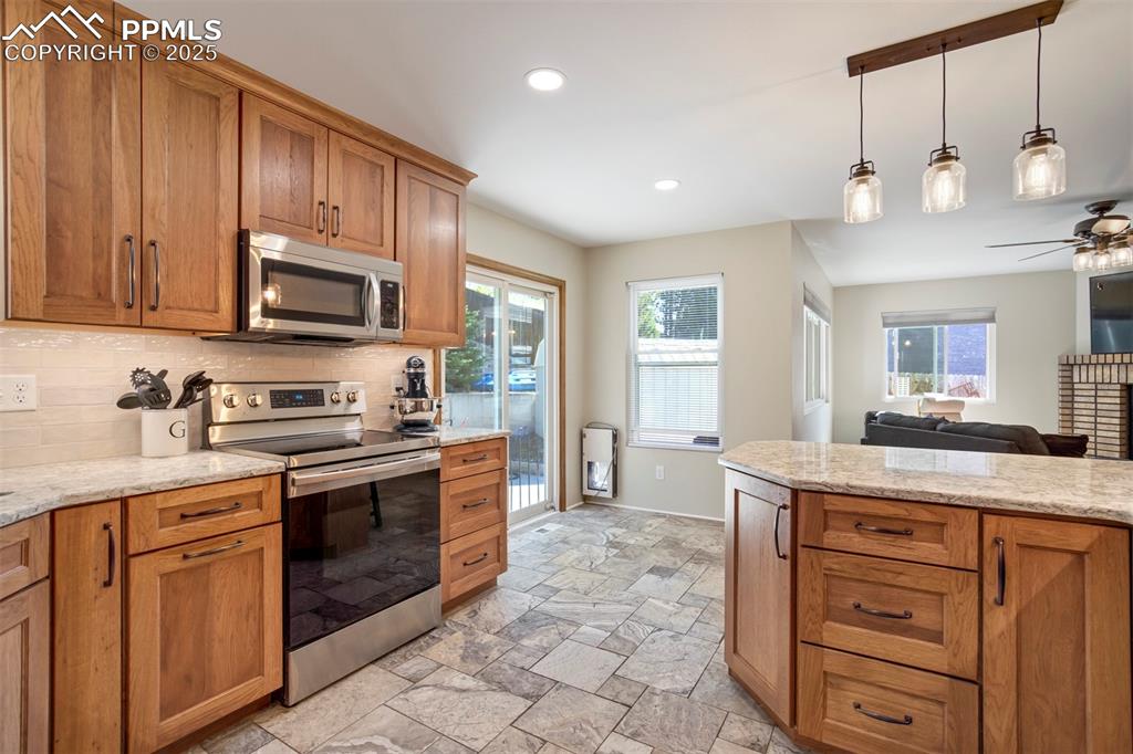 Image 18 of 50: Kitchen with appliances with stainless steel finishes, tasteful backsplash,