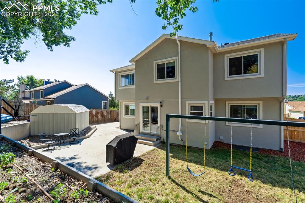 Image 2 of 50: Rear view of house featuring a fenced backyard, stucco siding, a patio, and