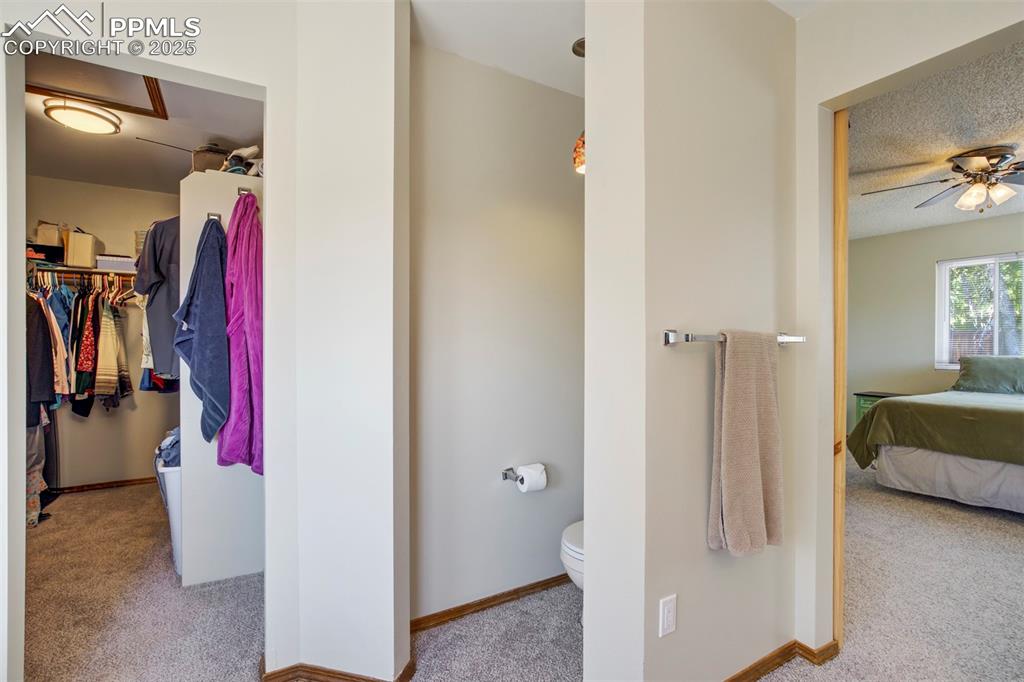 Image 25 of 50: Ensuite bathroom with toilet and a ceiling fan