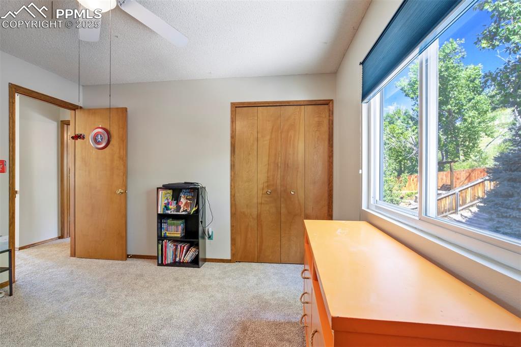 Image 32 of 50: Home office with carpet floors, a textured ceiling, and a ceiling fan