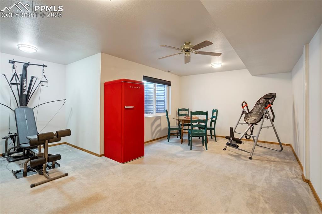 Image 36 of 50: Exercise room with ceiling fan and carpet flooring