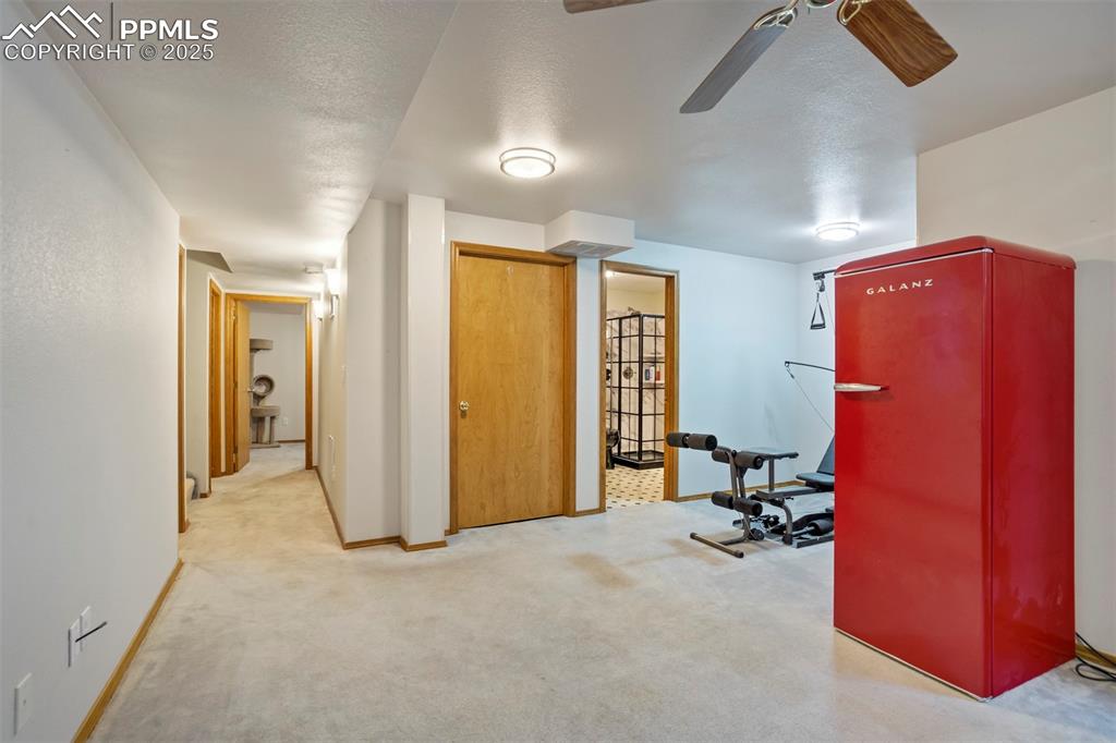 Image 37 of 50: Workout area featuring ceiling fan and carpet flooring