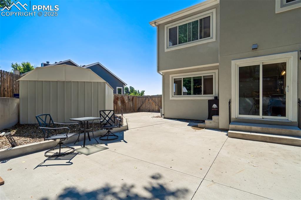 Image 45 of 50: Fenced backyard with entry steps, a patio area, and outdoor dining space