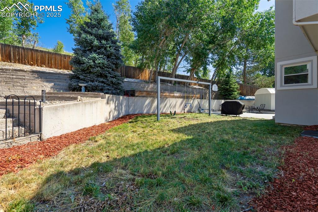 Image 46 of 50: Fenced backyard with a patio area
