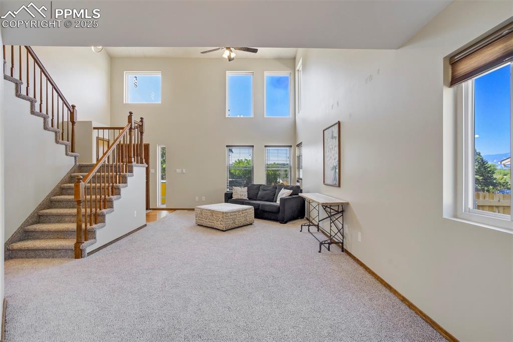 Image 8 of 50: Carpeted living room featuring healthy amount of natural light, ceiling fan